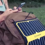 Chargeur panneau solaire SUNMOOVE 16W accroché en haut d'un sac de randonnée